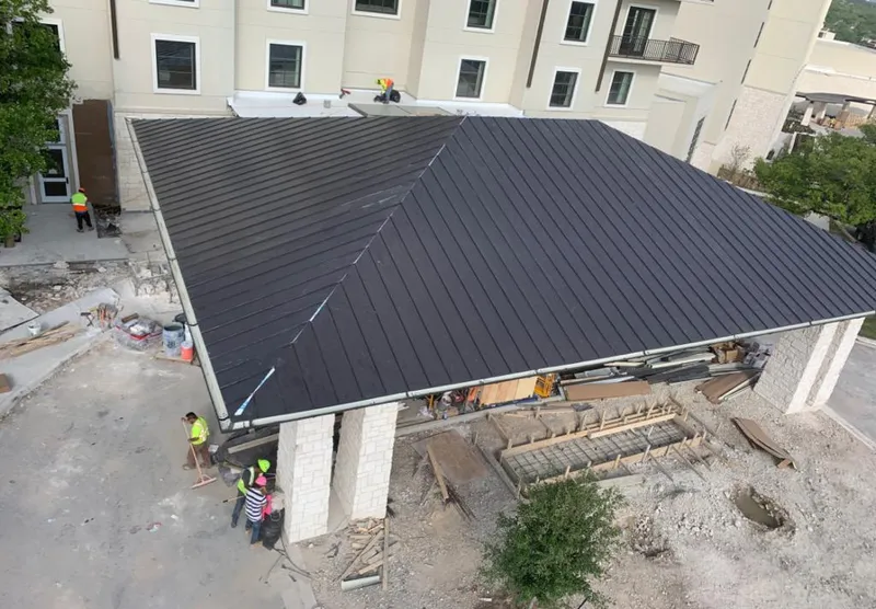Metal roofing installation team working on a commercial building in Monfort Heights
